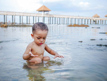 Portrait of shirtless boy playing in water