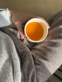 Hand holding a cup of sea buckthorn tea