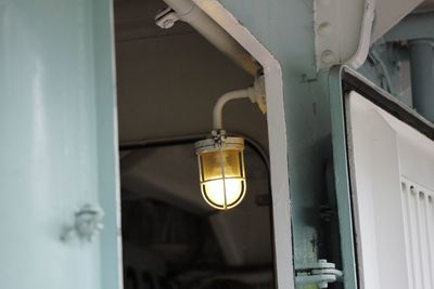 Low angle view of illuminated light bulb hanging from ceiling