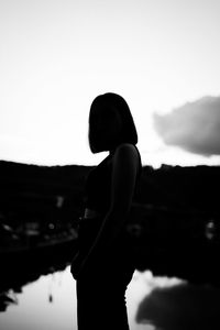 Side view of silhouette woman standing on mountain against sky