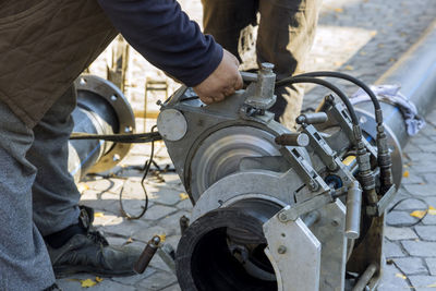 Low section of man working on motorcycle