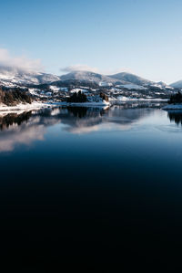 Scenic view of lake and snowcapped mountains against sky during winter