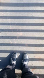 Low section of man standing on road