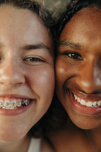 Happy teenage girl wearing braces by female friend