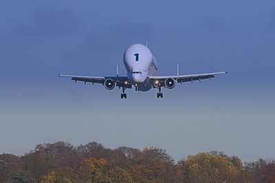 Low angle view of airplane flying against clear blue sky