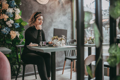 Woman sitting on table in restaurant