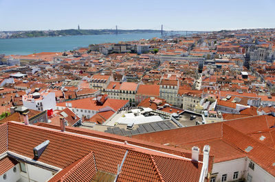 Aerial view of houses in city against april 25th bridge