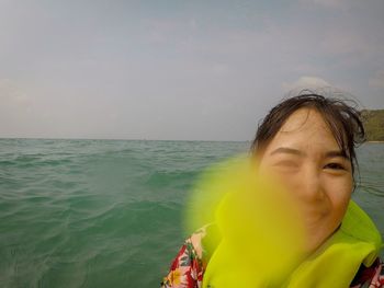 Portrait of woman against sea against sky