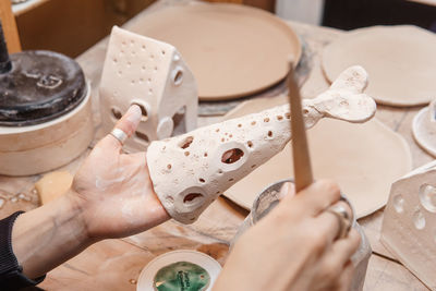 A master ceramist holds a clay product in his hands. making a ceramic candle holder from clay. 