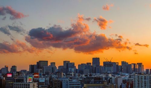 Modern buildings against sky during sunset