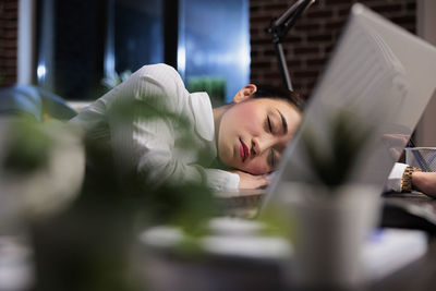 Tired businesswoman taking nap in office