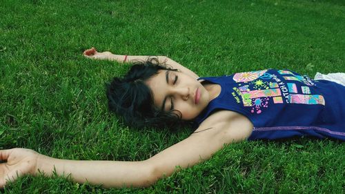 Young girl lying on grassy field