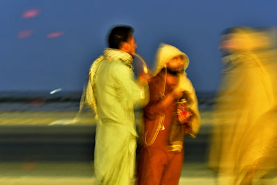 Blurred image of man and woman standing against sky