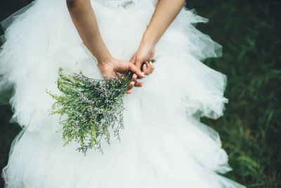 Close-up of woman with hand holding dress