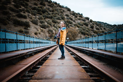 Portrait of woman standing on railroad track