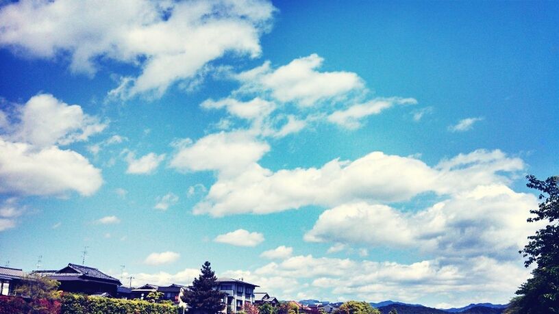 sky, building exterior, architecture, built structure, cloud - sky, low angle view, blue, tree, cloud, house, day, cloudy, residential structure, nature, outdoors, residential building, no people, mountain, town, sunlight