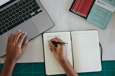 Cropped hands of woman using laptop