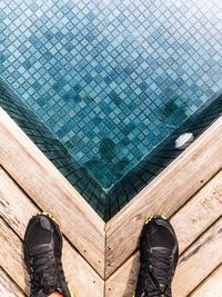 Low section of man standing on swimming pool