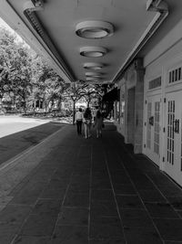 People in illuminated corridor