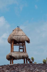 Low angle view of hut on land against sky