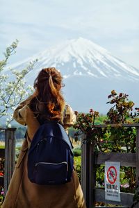 Rear view of woman looking away against sky