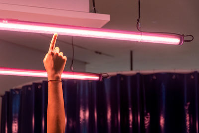 Midsection of person with illuminated lights in background