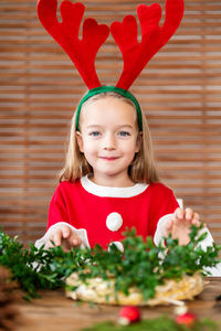 Portrait of cute girl wearing antler at home