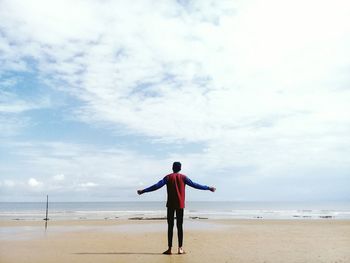 Full length of man standing on beach against sky