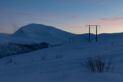 Scenic view of snow covered mountain against sky during sunset