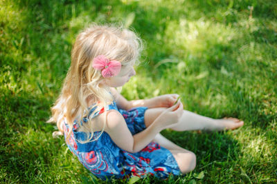High angle view of girl sitting on grass