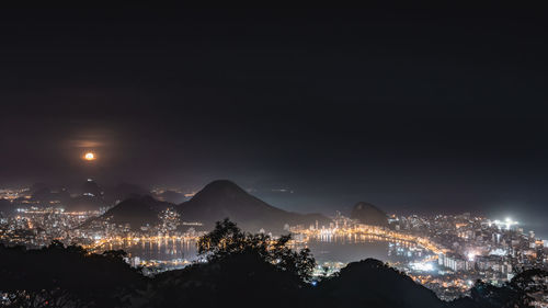 Illuminated city against sky at night