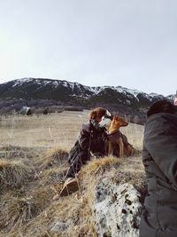 People on mountain against sky during winter