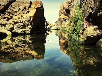 Rock formations reflecting on calm lake