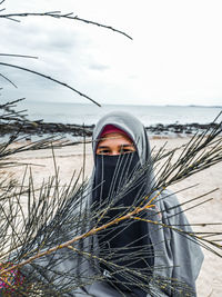 Portrait of woman by sea against sky