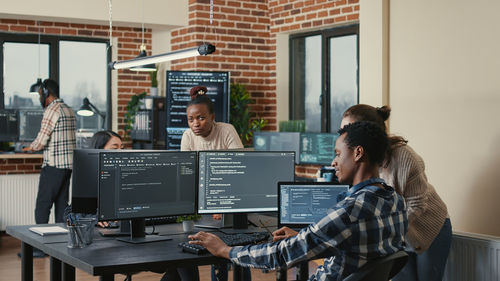 Smiling business people using computer at office