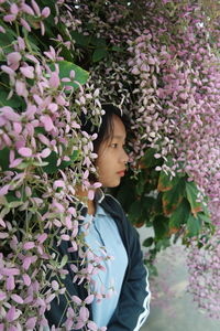 Rear view of child standing on flowering plant