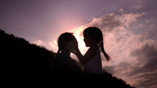 Silhouette couple against sky during sunset