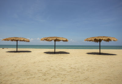 Umbrellas on beach against sky