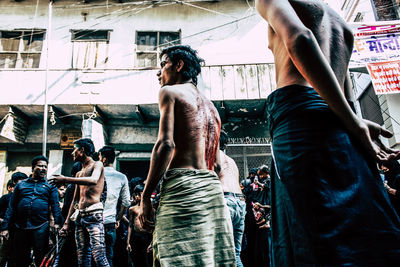 Rear view of people standing in city