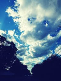 Low angle view of silhouette trees against sky