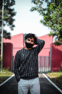 Full length of young man standing against tree