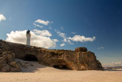 Rock formations on beach against sky