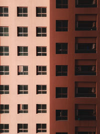 Exterior shot showing a symmetrical pattern of windows and balconies on a building 