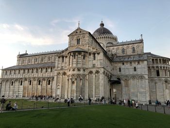 People in front of historical building against sky