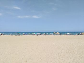 Group of people on beach against sky