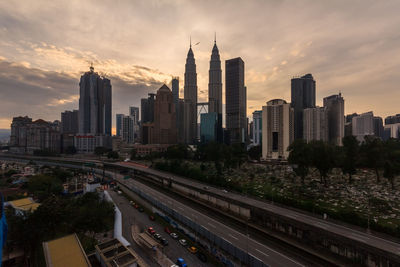 View of buildings in city against cloudy sky