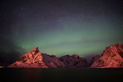 Scenic view of aurora borealis over mountains