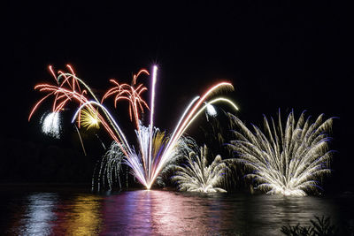 Firework display over river at night