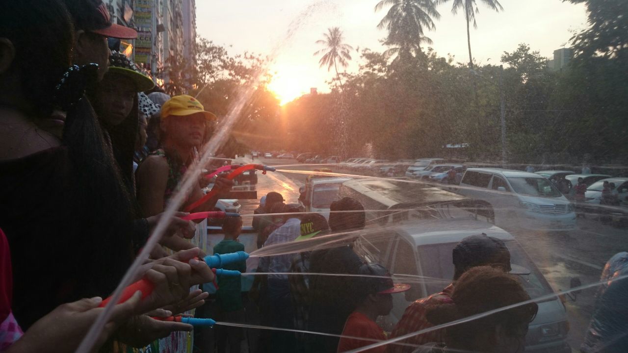 lifestyles, sun, leisure activity, sunbeam, men, person, sunlight, large group of people, transportation, lens flare, unrecognizable person, holding, mode of transport, car, part of, tree