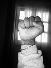 Close-up of hands against window at home